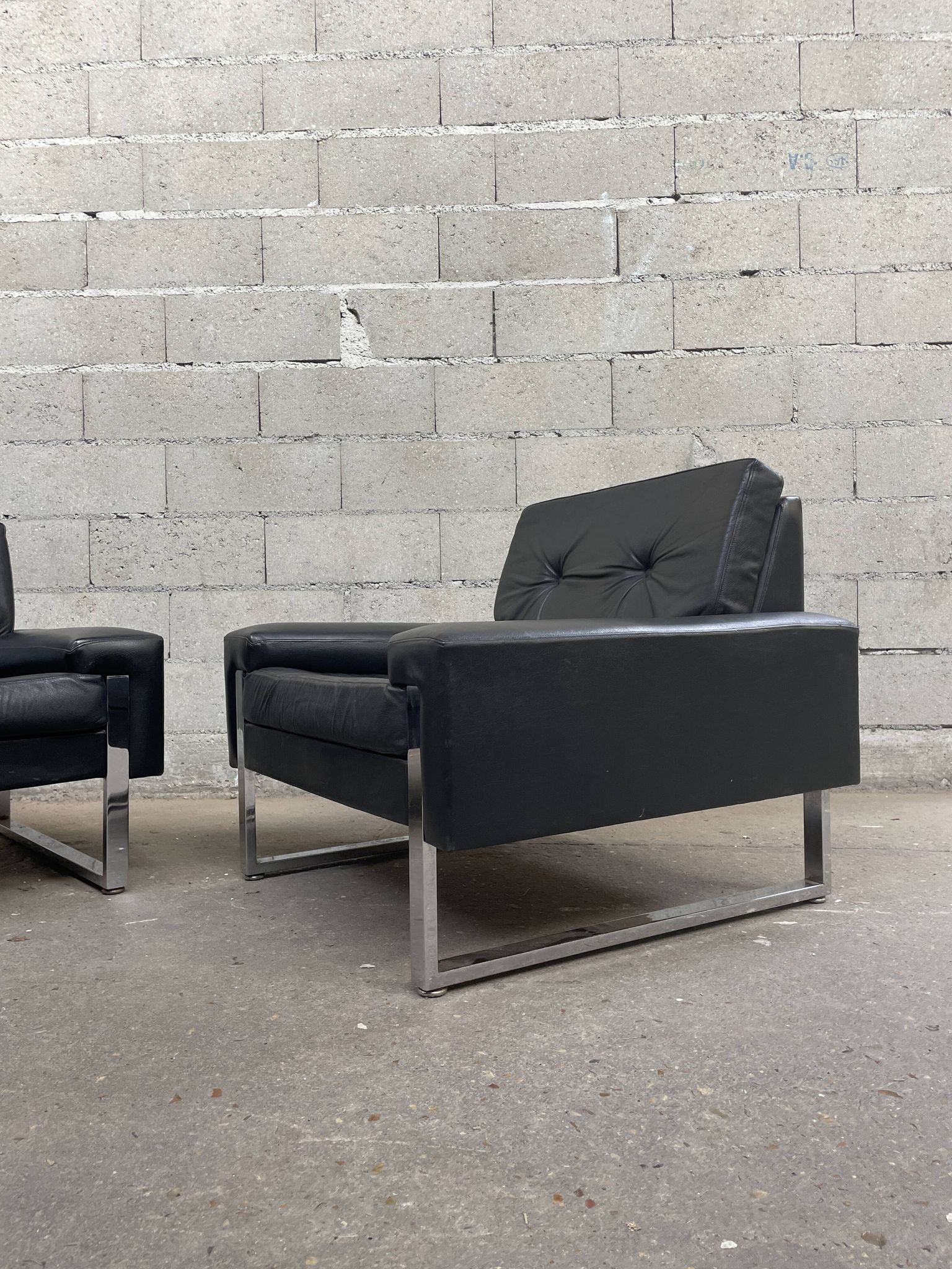 Pair of black leather armchairs