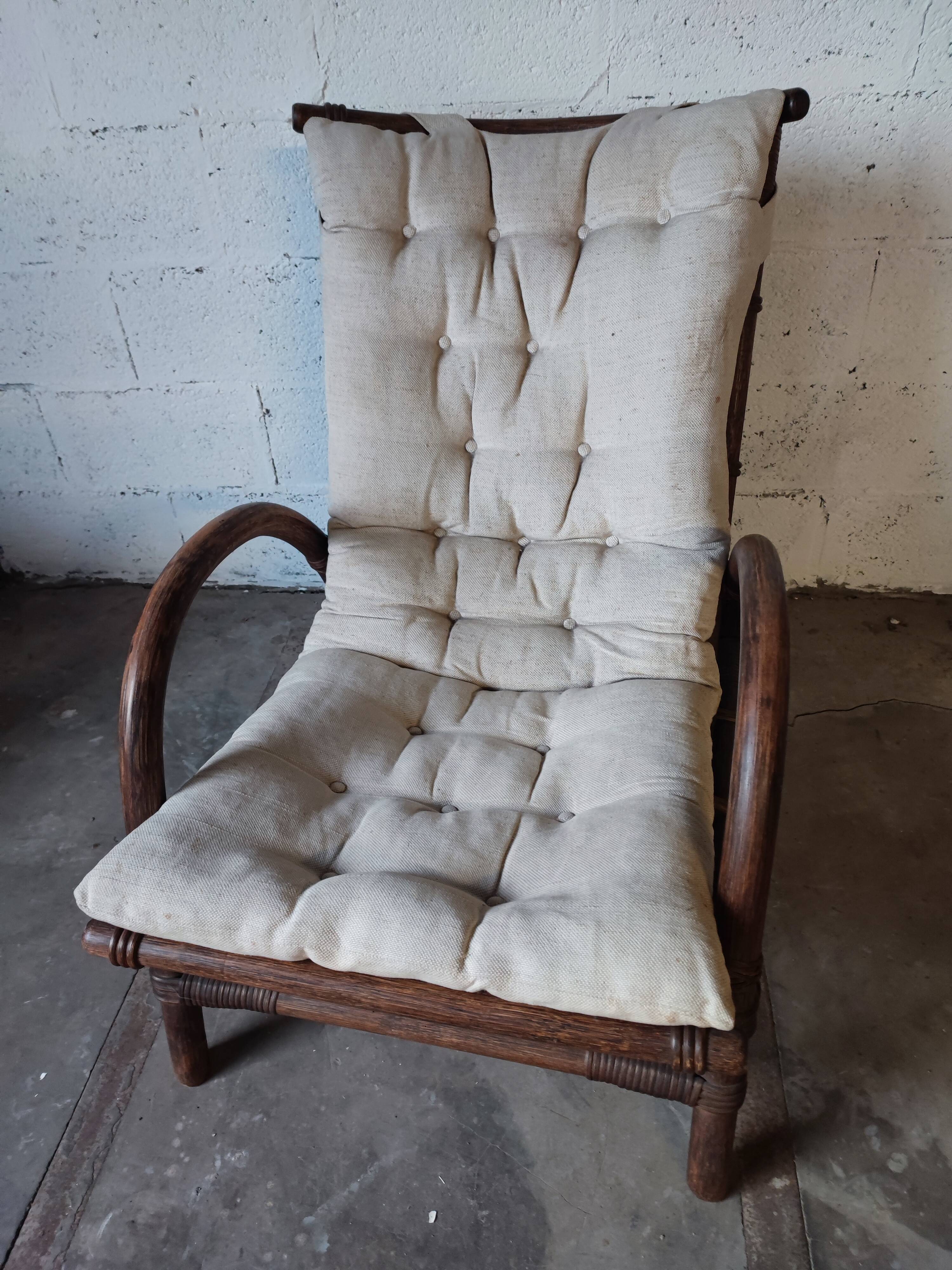 Relaxed armchair in bamboo and rattan with its small side table. Beige linen cushion.