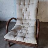 Relaxed armchair in bamboo and rattan with its small side table. Beige linen cushion.