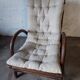 Relaxed armchair in bamboo and rattan with its small side table. Beige linen cushion.