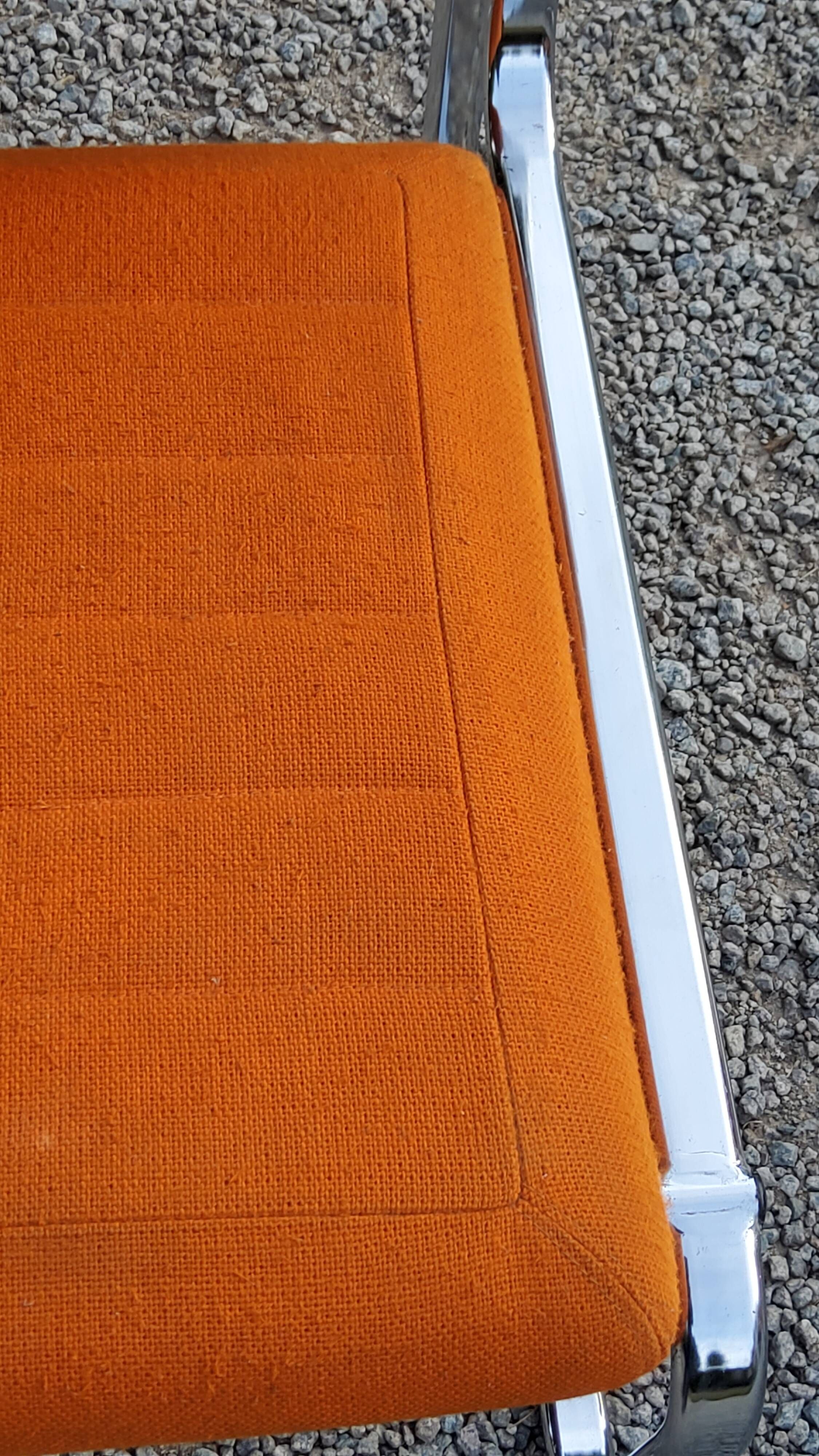 Pair of designer armchairs in orange fabrics and chrome tubes from the 70s