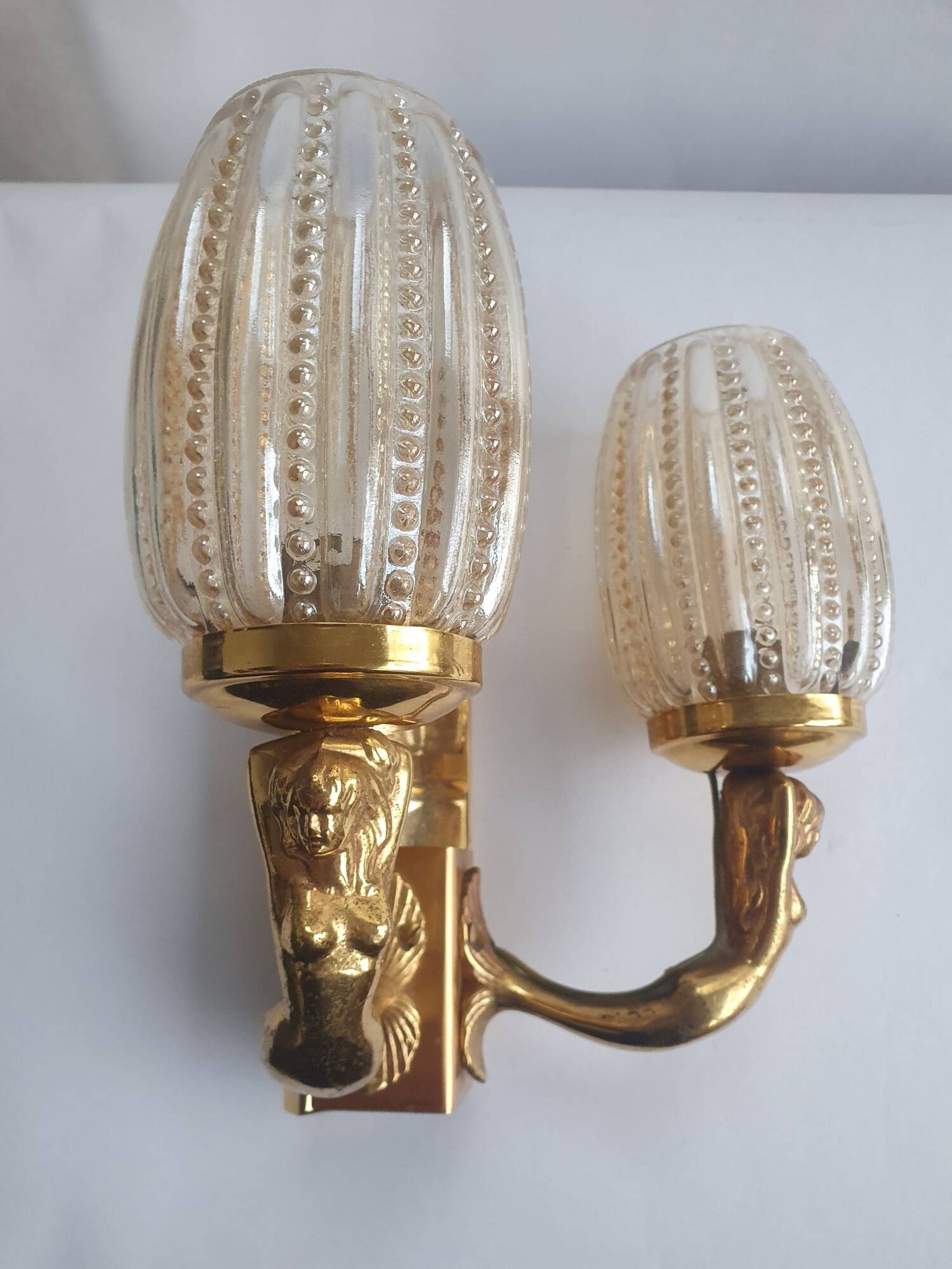 Golden bronze wall lamp with mermaids for an old bathroom.