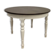 Restored solid wood round table with integrated extensions.