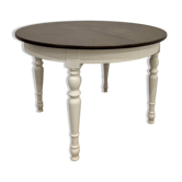 Restored solid wood round table with integrated extensions.