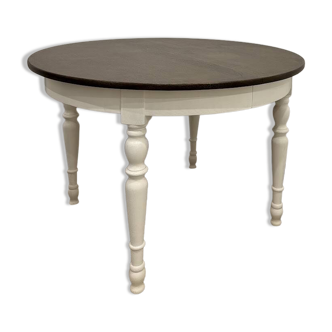 Restored solid wood round table with integrated extensions.