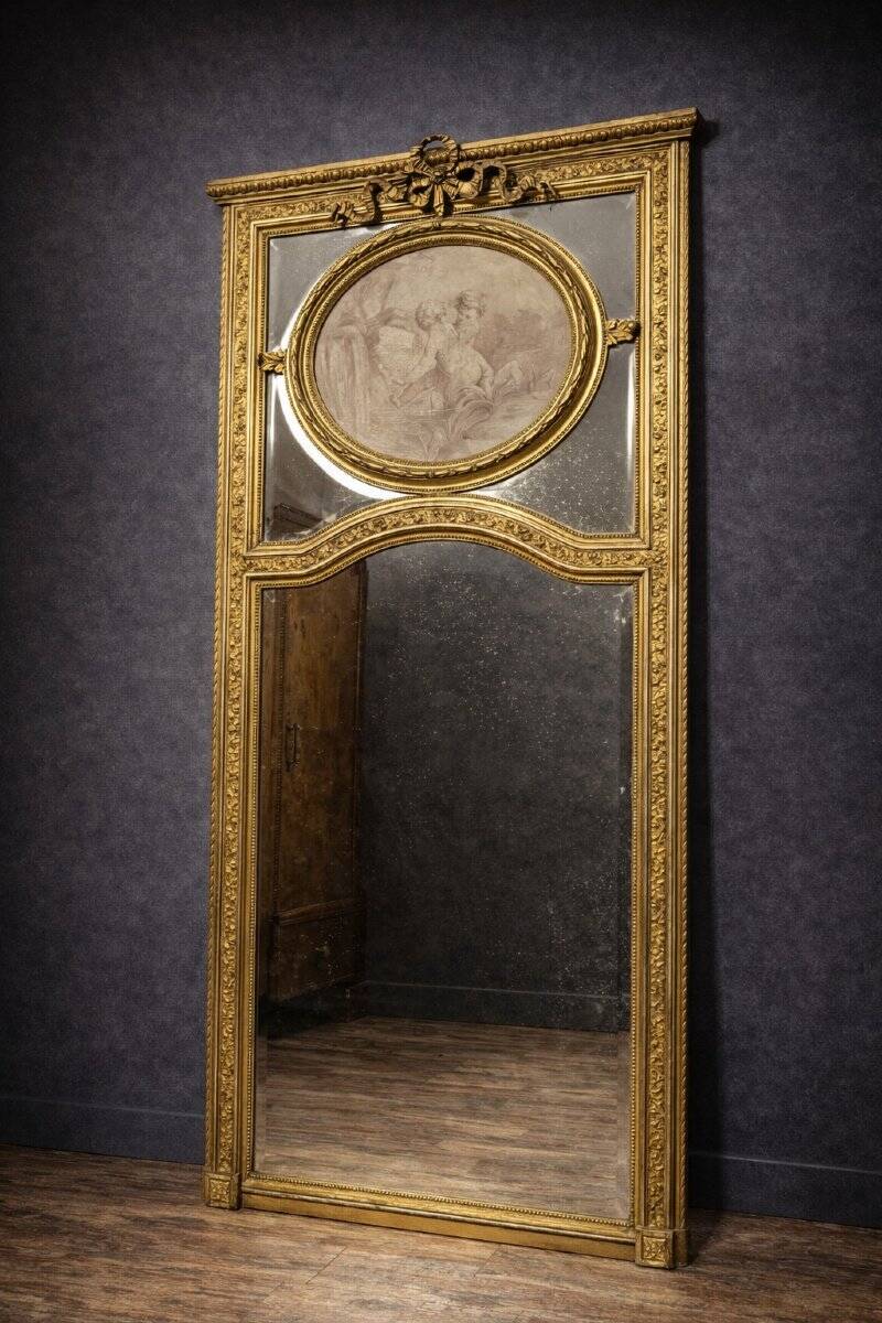 Very large mirror with mouldings, richly carved and gilded, in the Louis XVI style.