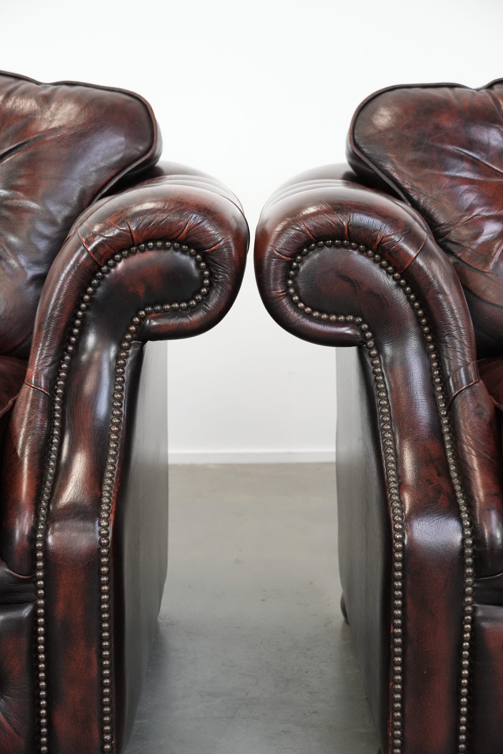 Set of two marbled cowhide leather Chesterfield armchairs in English style