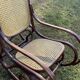 Thonet rocking chair in curved brown wood, period seat, 19th-century bentwood style.
