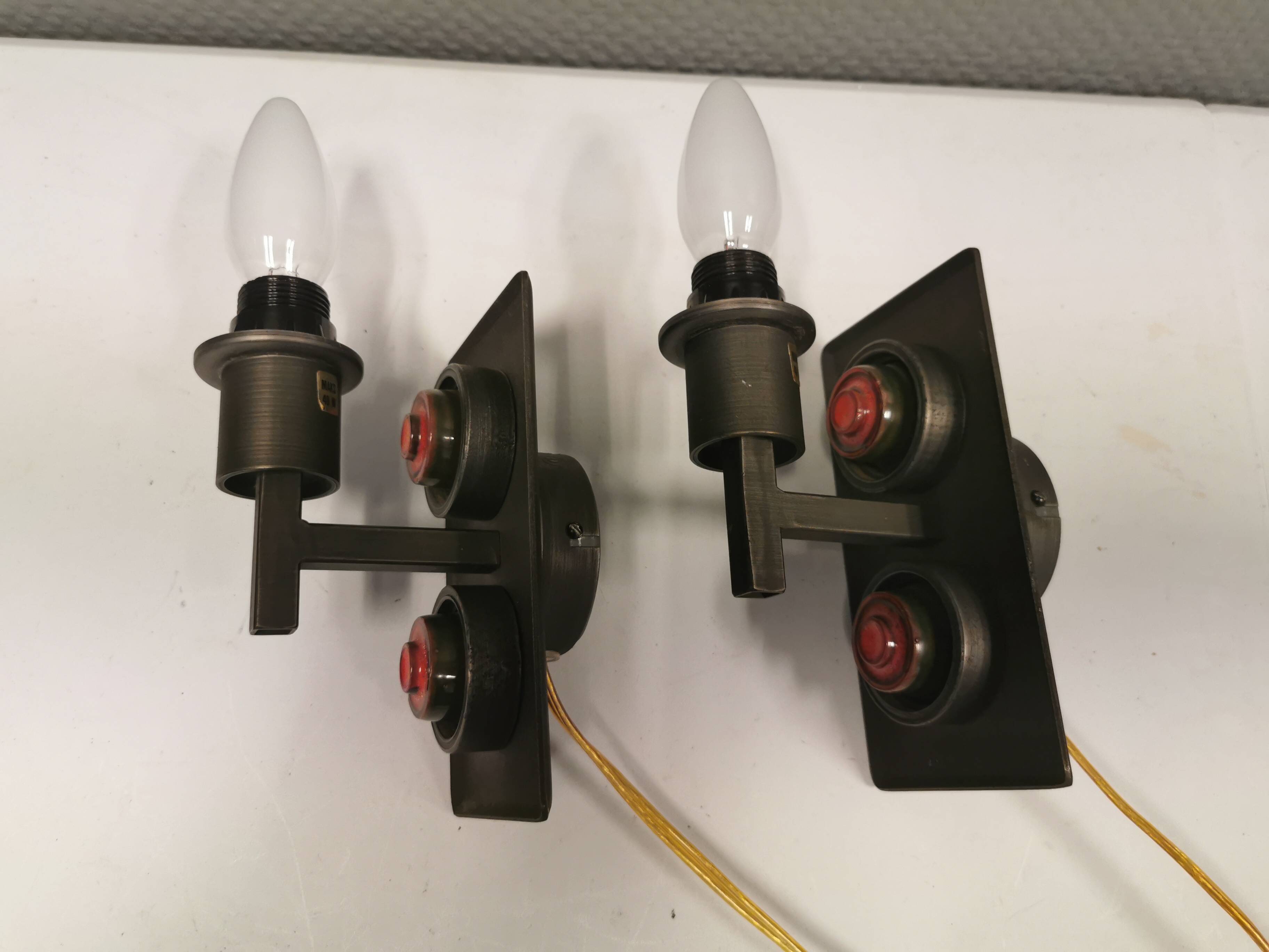 A set of Vitrika Denmark, cast iron wall lights with red details.