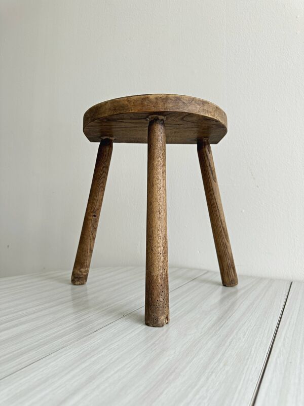 Tabouret tripode ancien en bois clair, assise demi-lune
