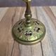 Antique brass candlestick with patina, openwork vintage foliage decoration.