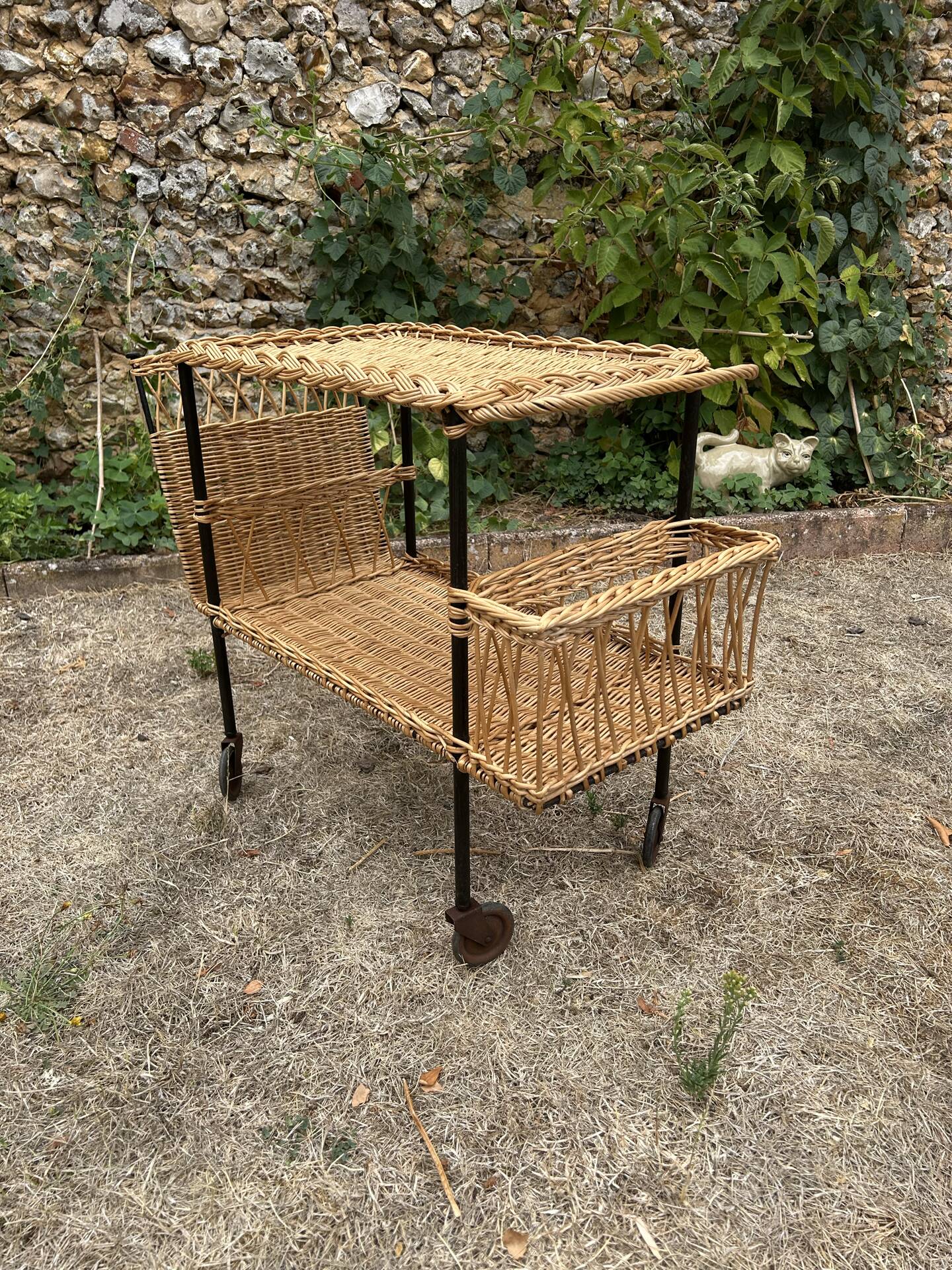 Vintage 1950s rolling dessert trolley in wicker and black tubing.