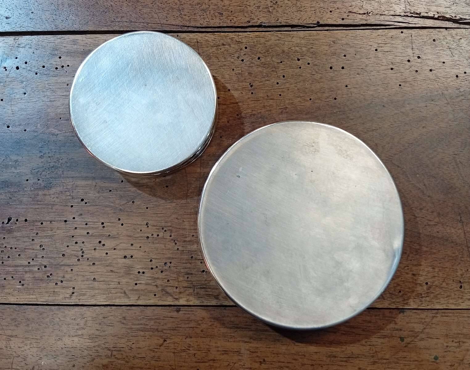 A pair of silver-plated bottle coasters for 75cl and 25cl.