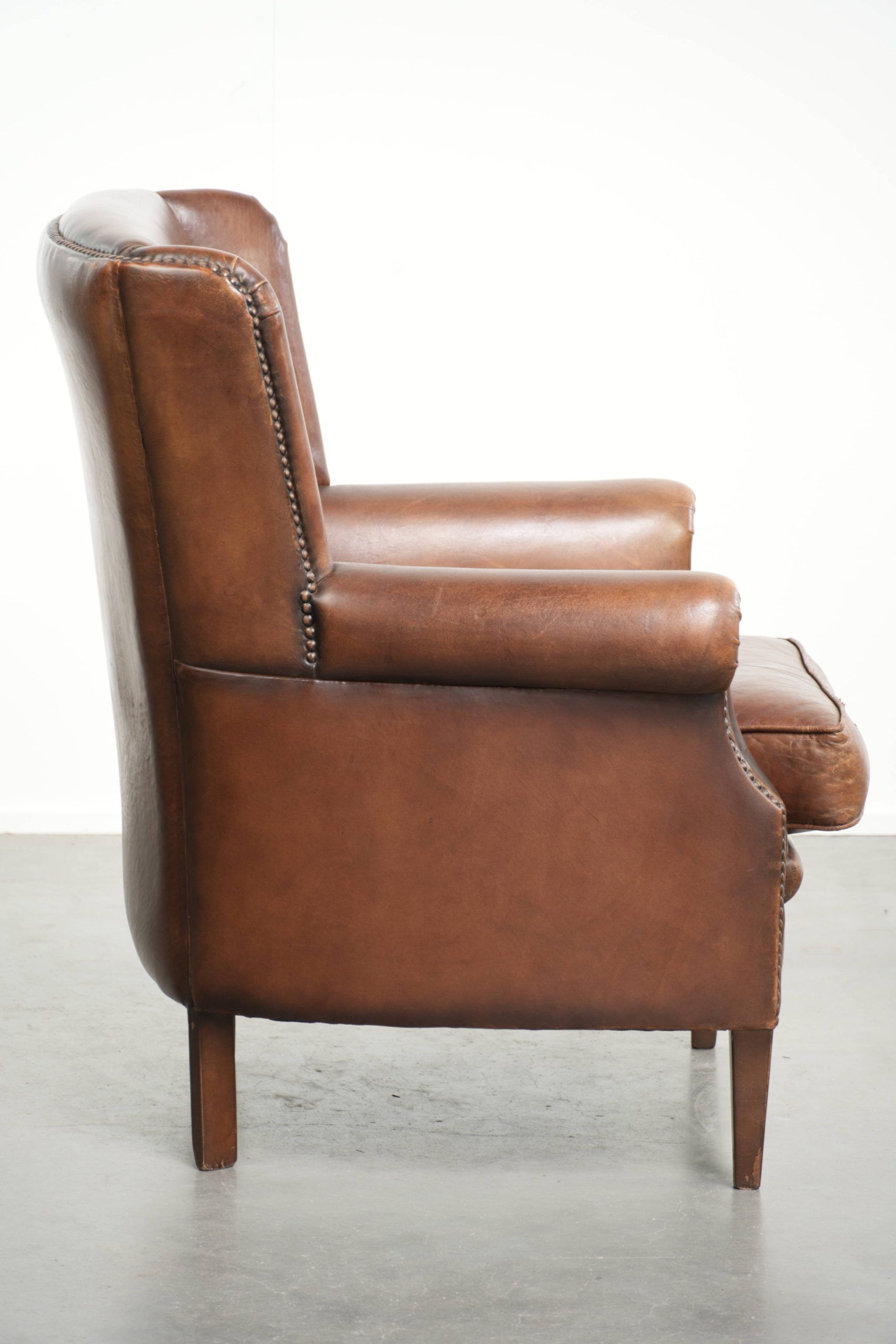 Subtle dark brown sheepskin wingback armchair with a timeless look subtle