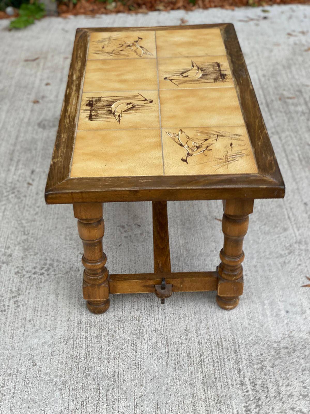 Vintage 70s coffee table with wood and ceramic tiles featuring bird and nature patterns.