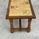 Vintage 70s coffee table with wood and ceramic tiles featuring bird and nature patterns.