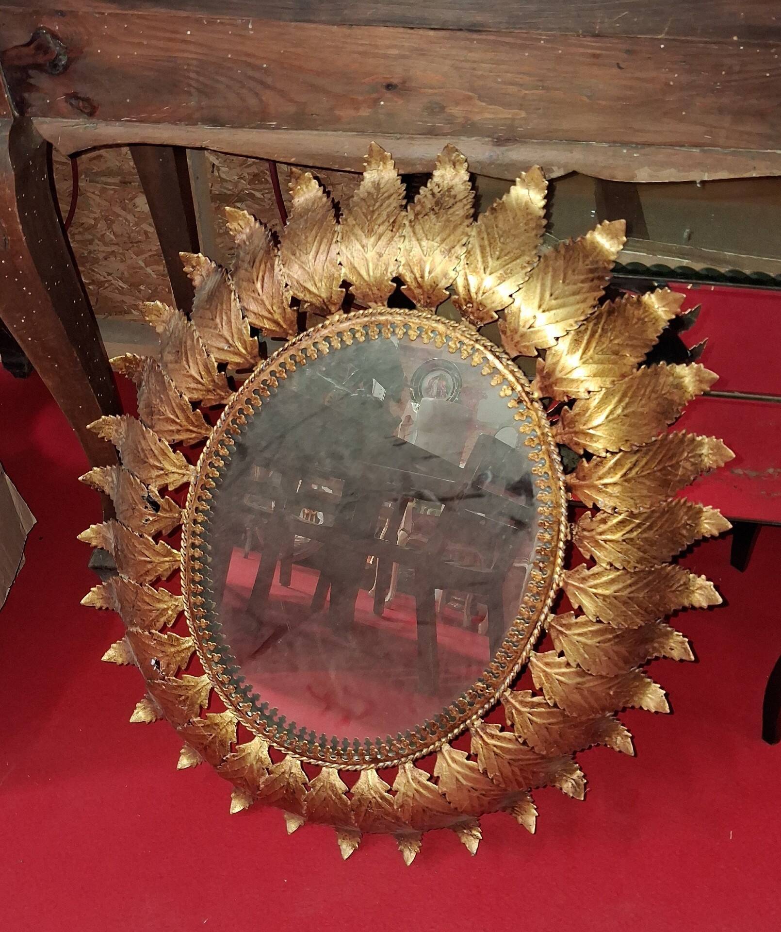Golden metal sun mirror with leaf decoration