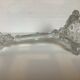 Thick moulded glass candlestick with fish and flowers.