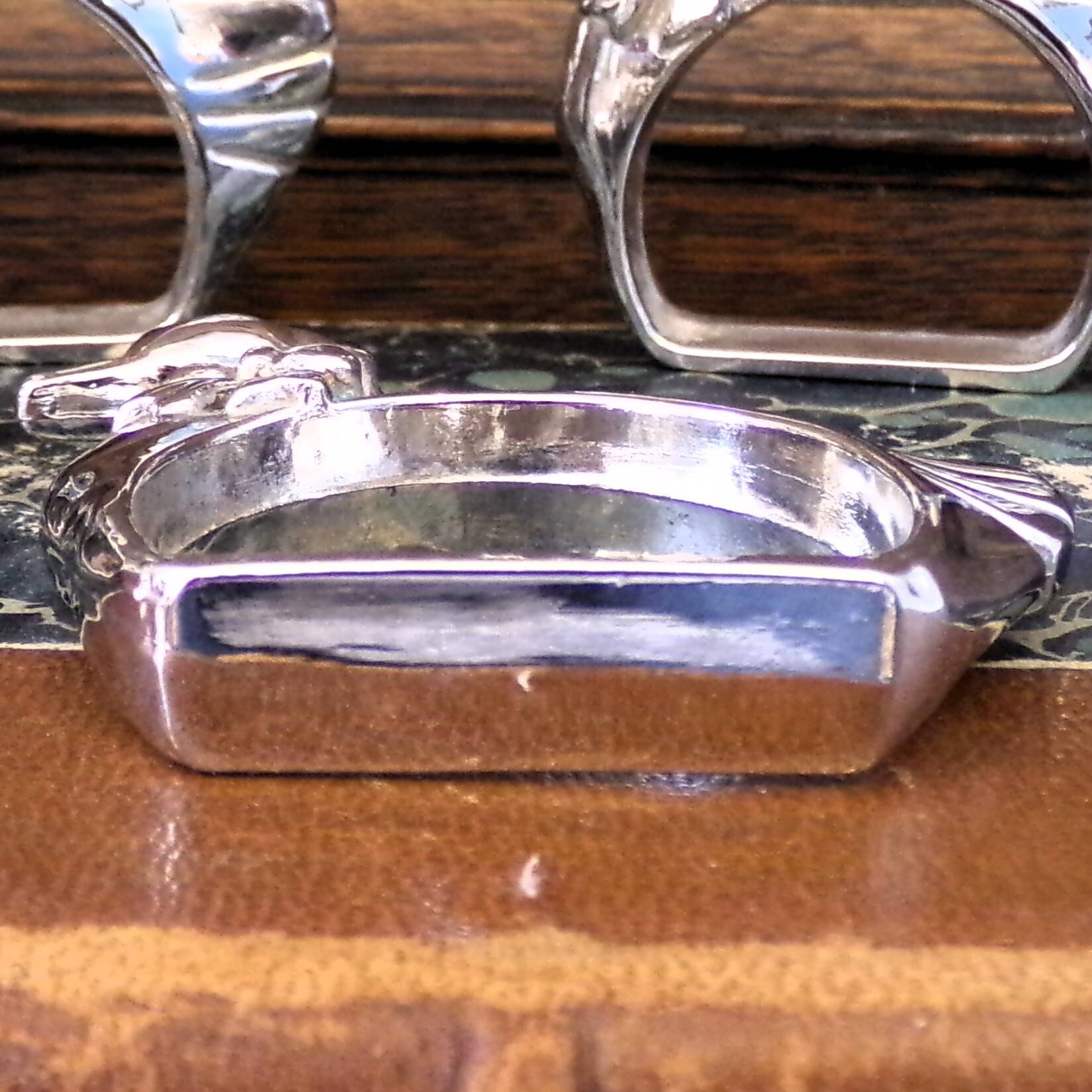 Four silver-plated napkin rings in the shape of a duck/goose