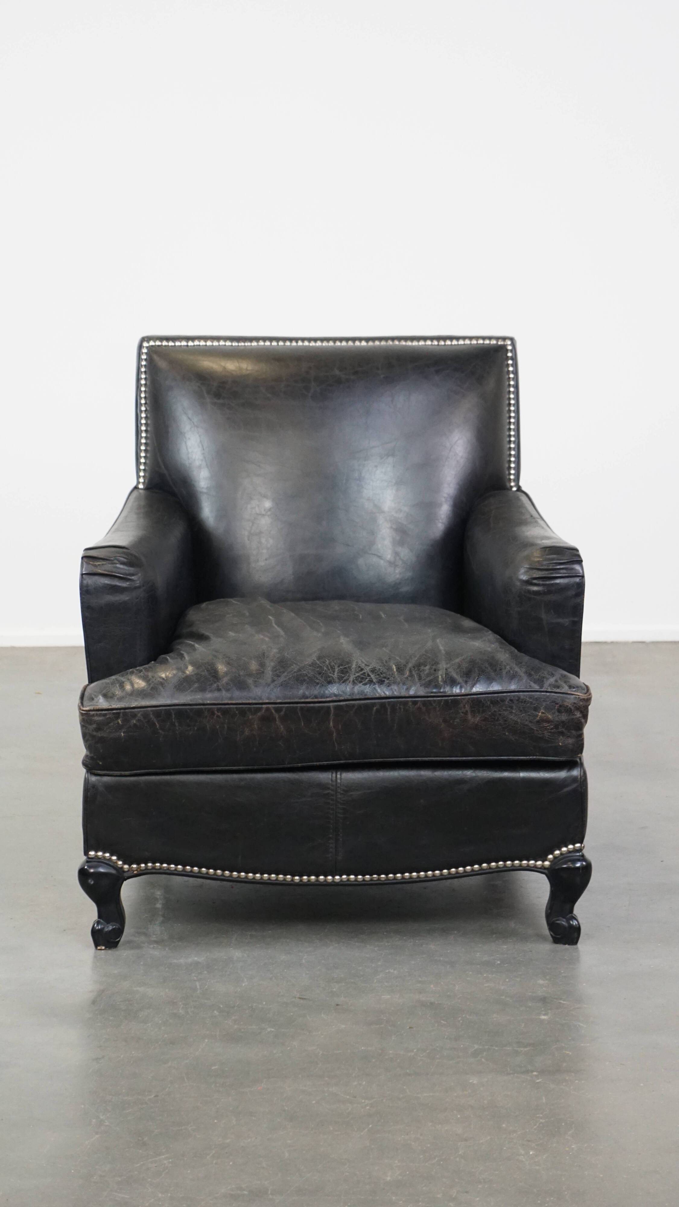 Armchair in black grained cowhide leather with a deep seat