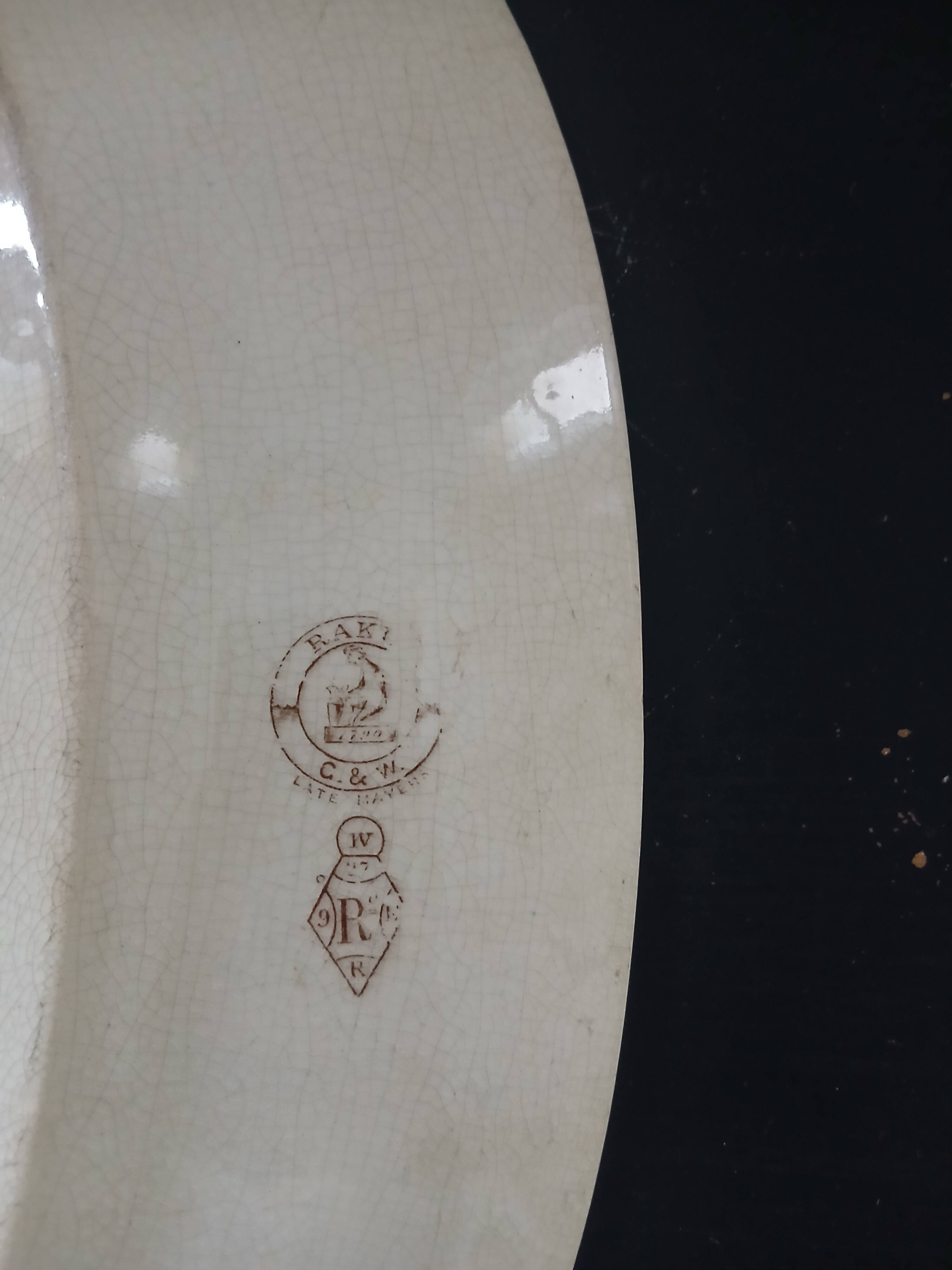 Large antique plate stamped with a fauna and flora pattern.