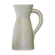 White ceramic pitcher with green background