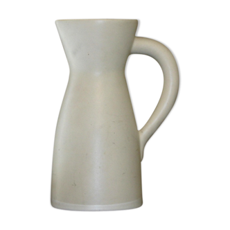 White ceramic pitcher with green background