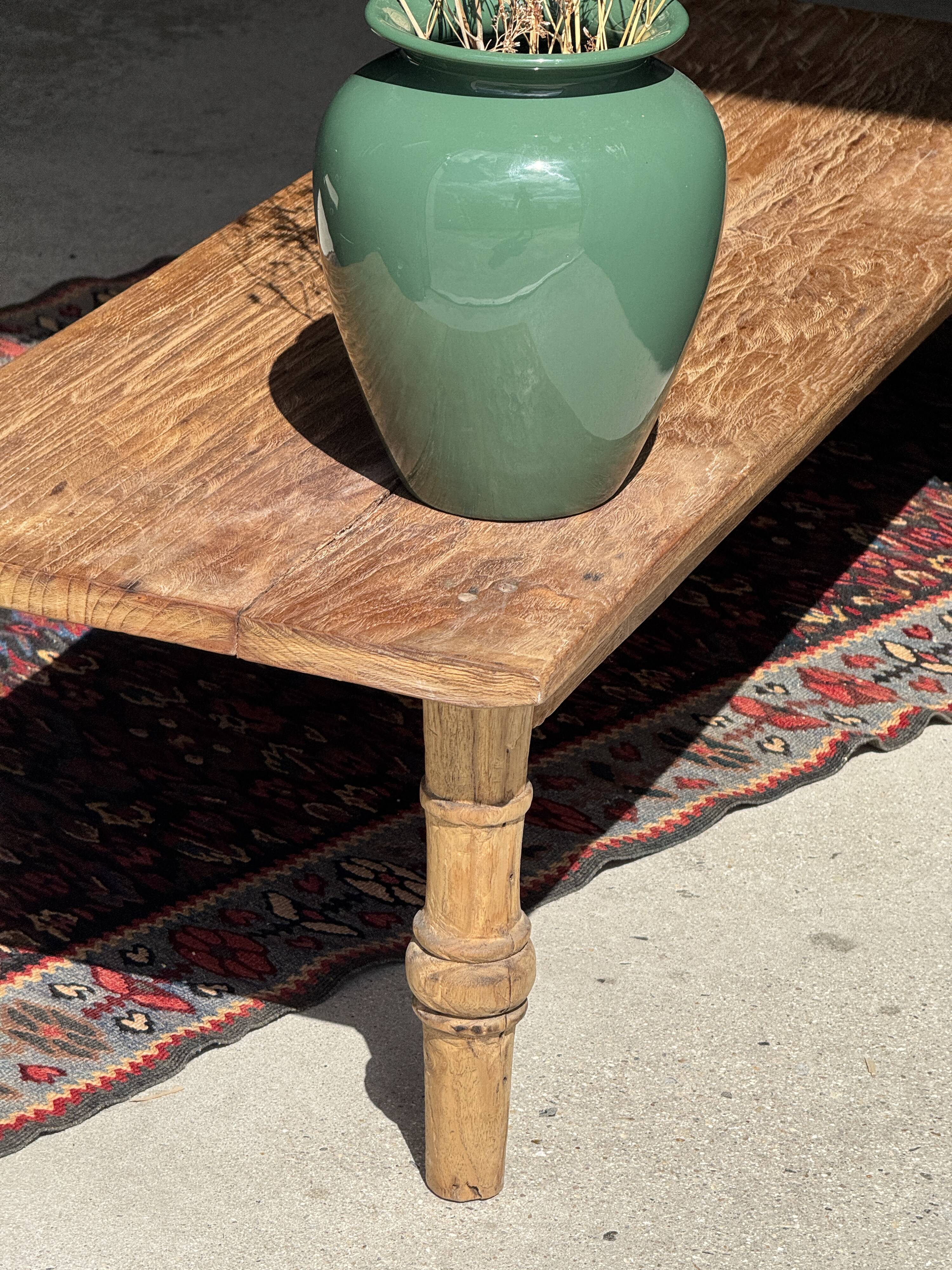 Brown Indonesian teak coffee table, with a border and cylindrical legs H40 L103.