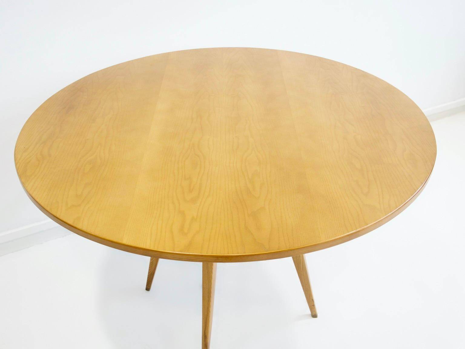 Round dining table in Wood Wood with brass details.