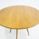 Round dining table in Wood Wood with brass details.