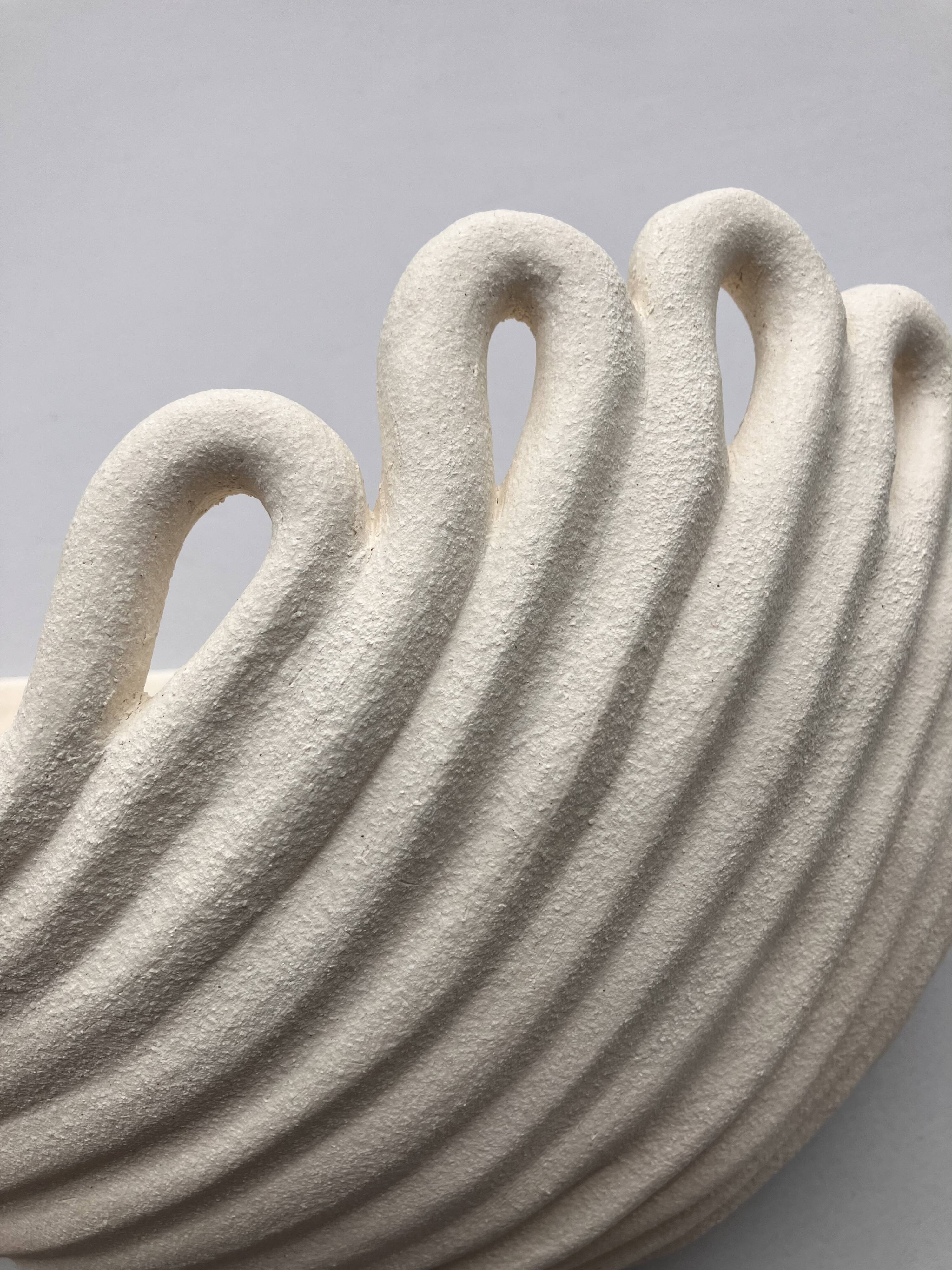 Draped ceramic wall light in a half-moon shape.