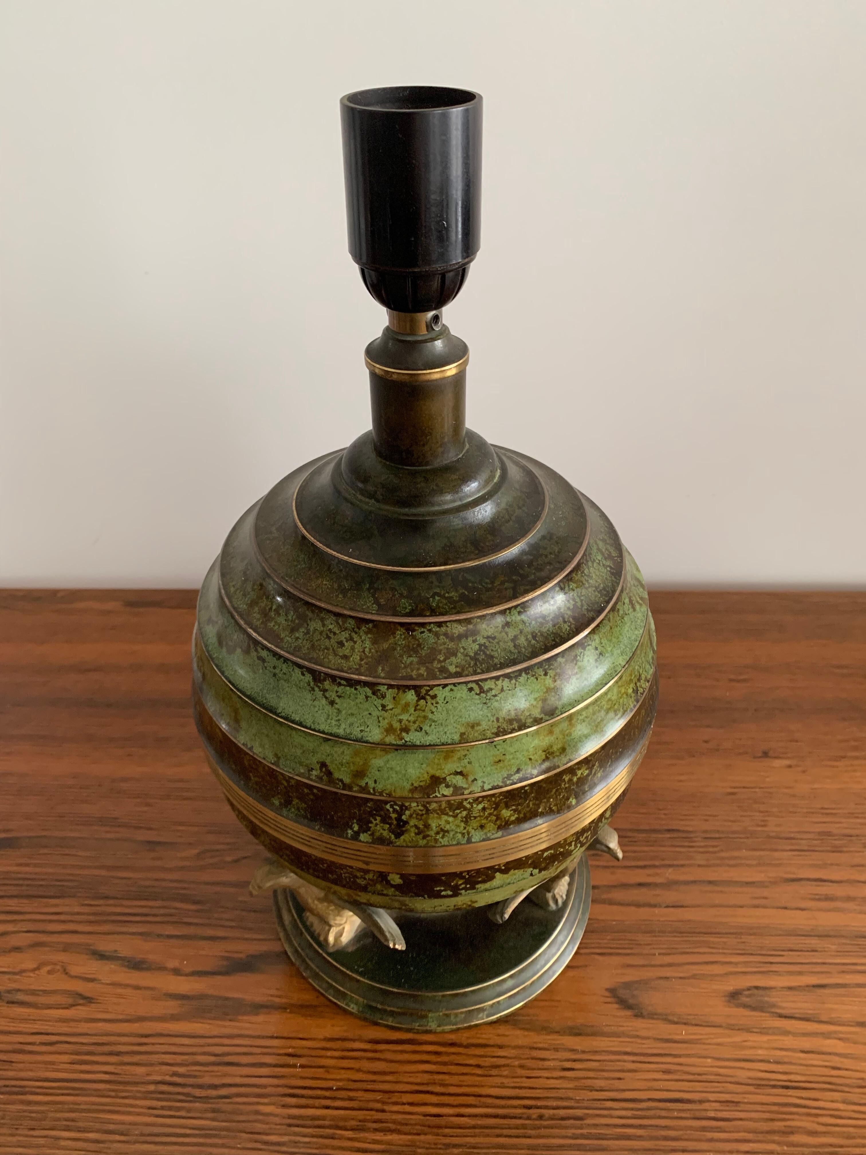 Art Deco table lamp in patinated bronze with eagles holding a globe, France 1940.