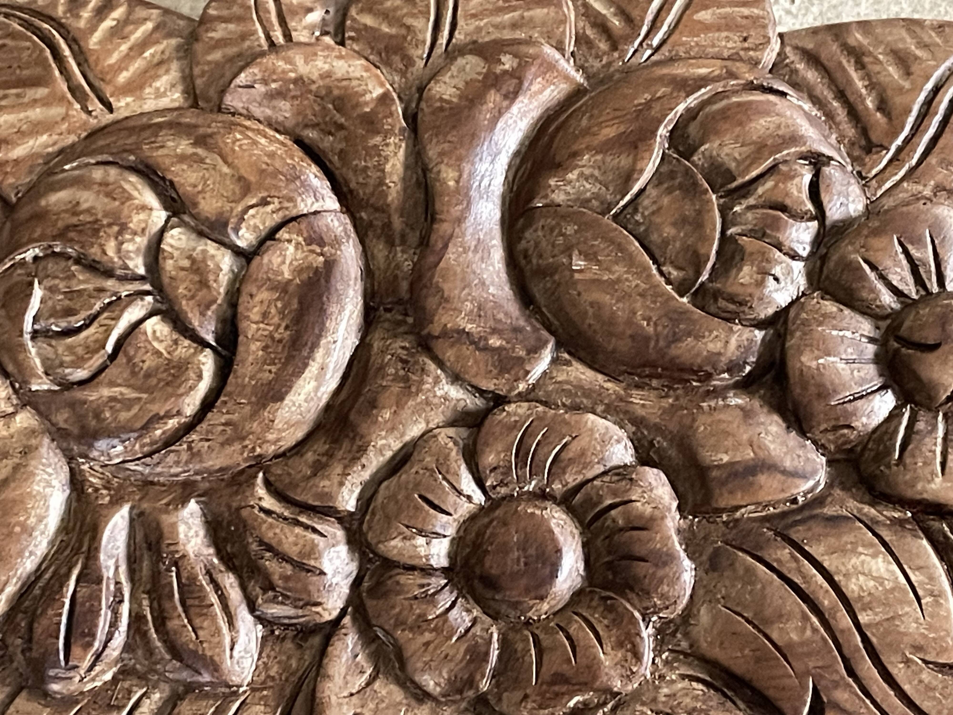 Wall-mounted coat rack on a carved wooden pediment