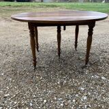 Table ronde en noyer de 130 cm de diamètre .