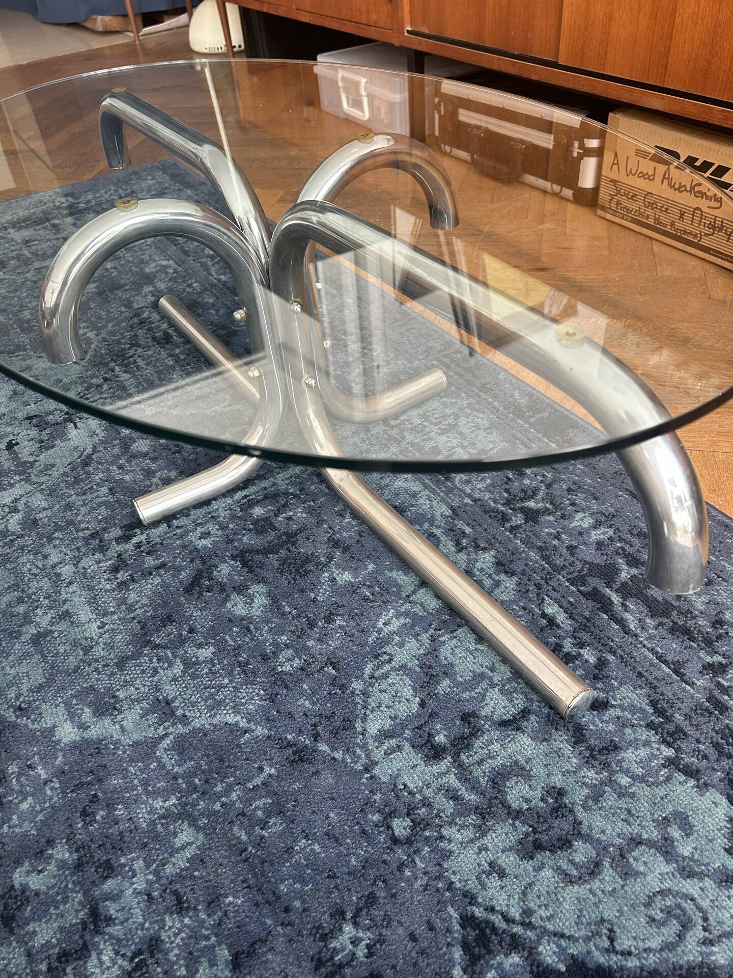 Oval glass coffee table with chrome legs, vintage 70s design.