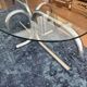 Oval glass coffee table with chrome legs, vintage 70s design.
