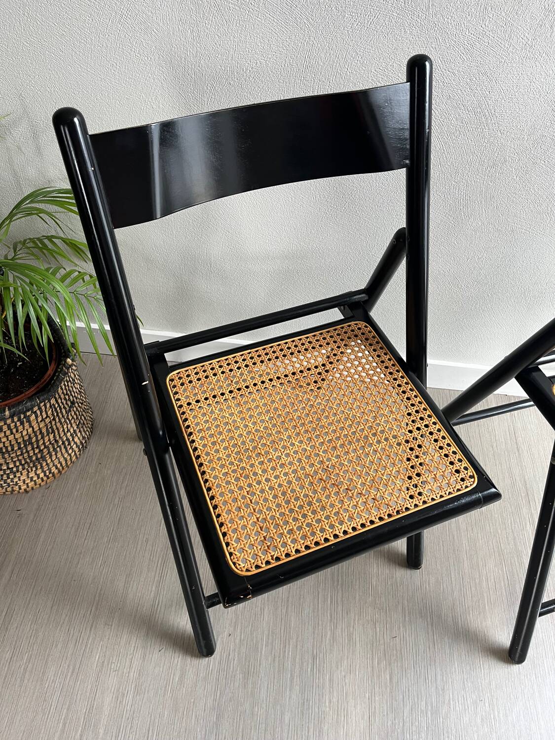 Vintage folding chairs in black wood and cane.