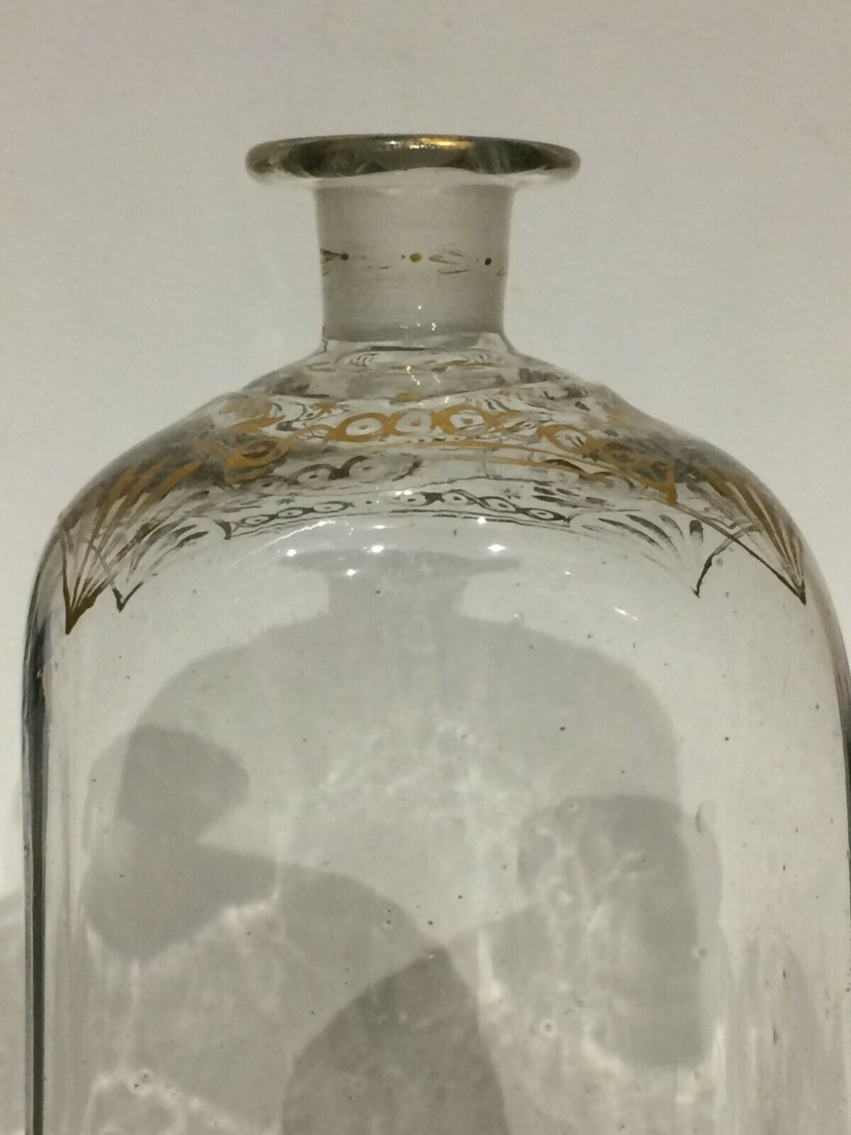 Glass bottle decorated with gold motifs