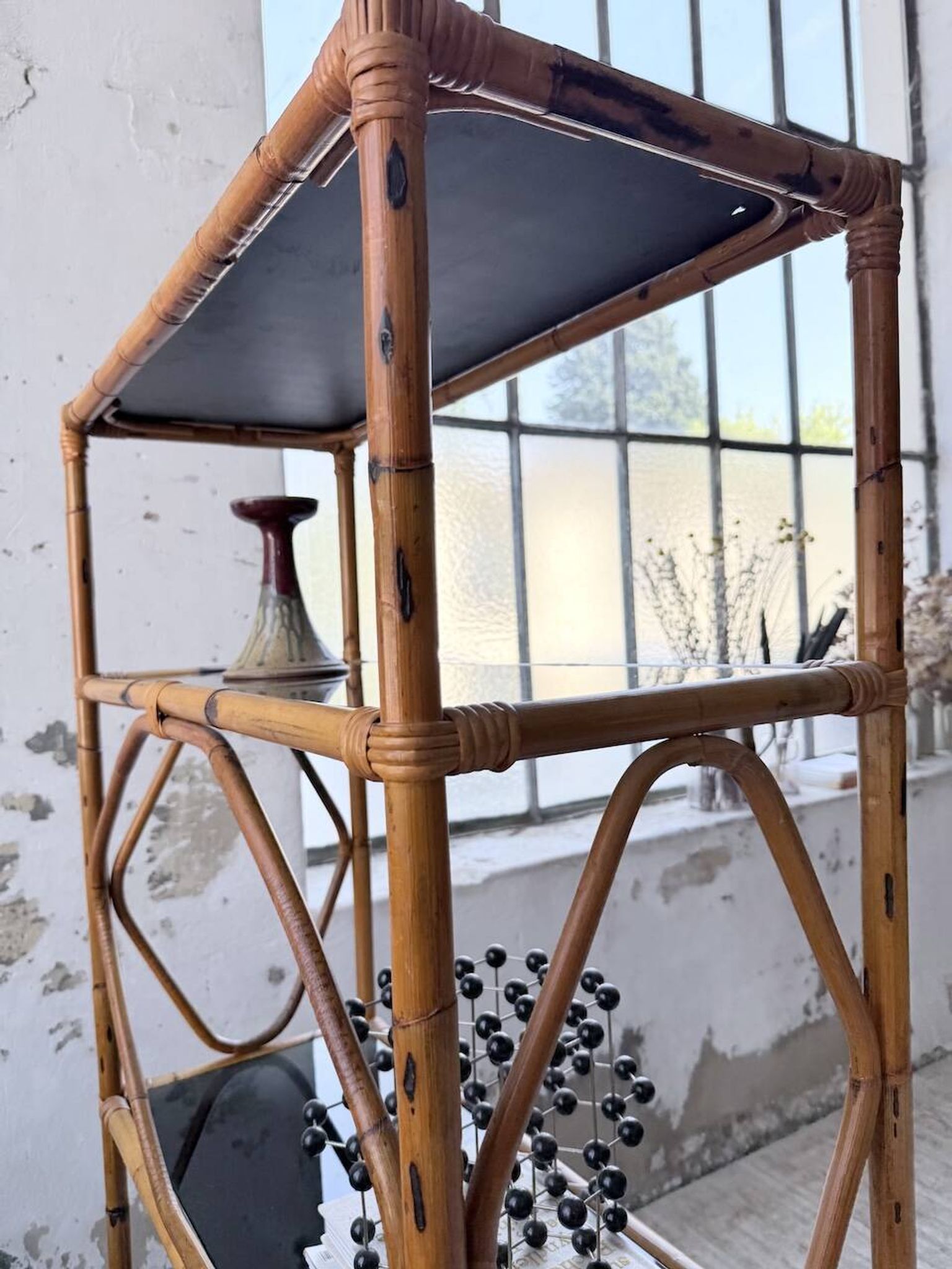 Rattan bookshelf and black glasses