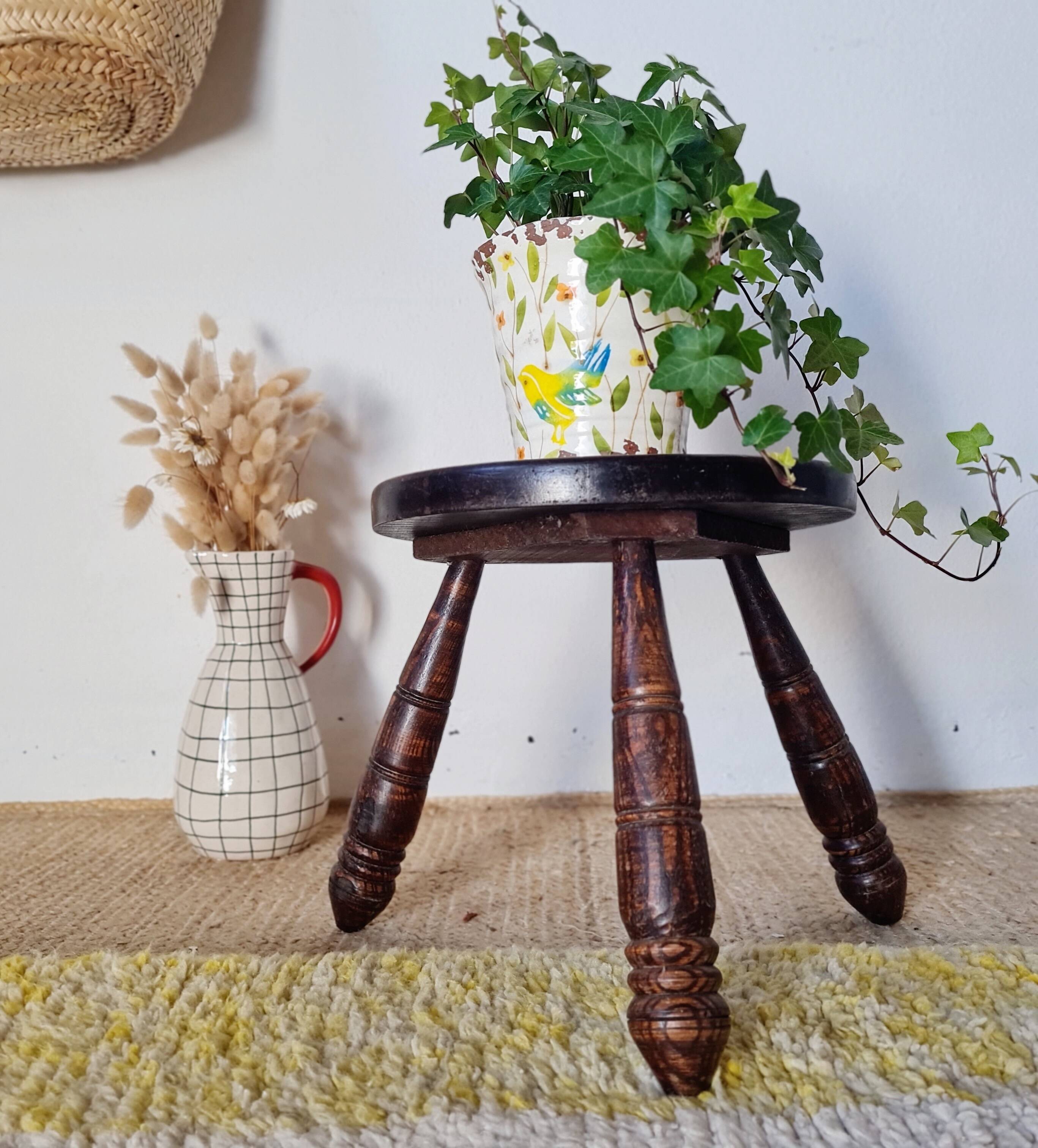 Small brutalist tripod stool made of turned wood.