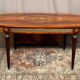 Louis XVI style oval dining table with rosewood marquetry extension mounted in bronze
