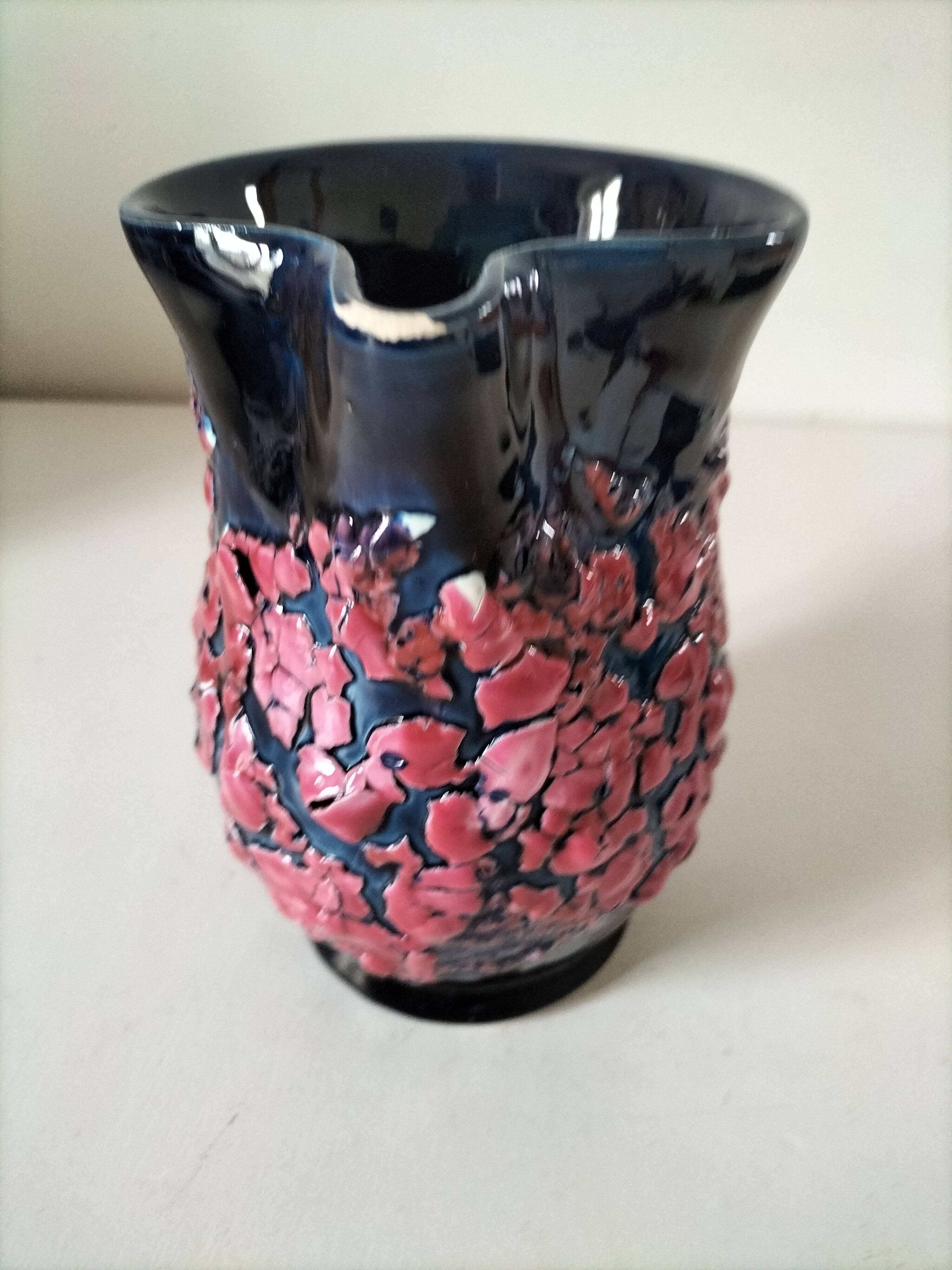 Vintage pitcher in midnight blue glazed ceramic with bright pink relief