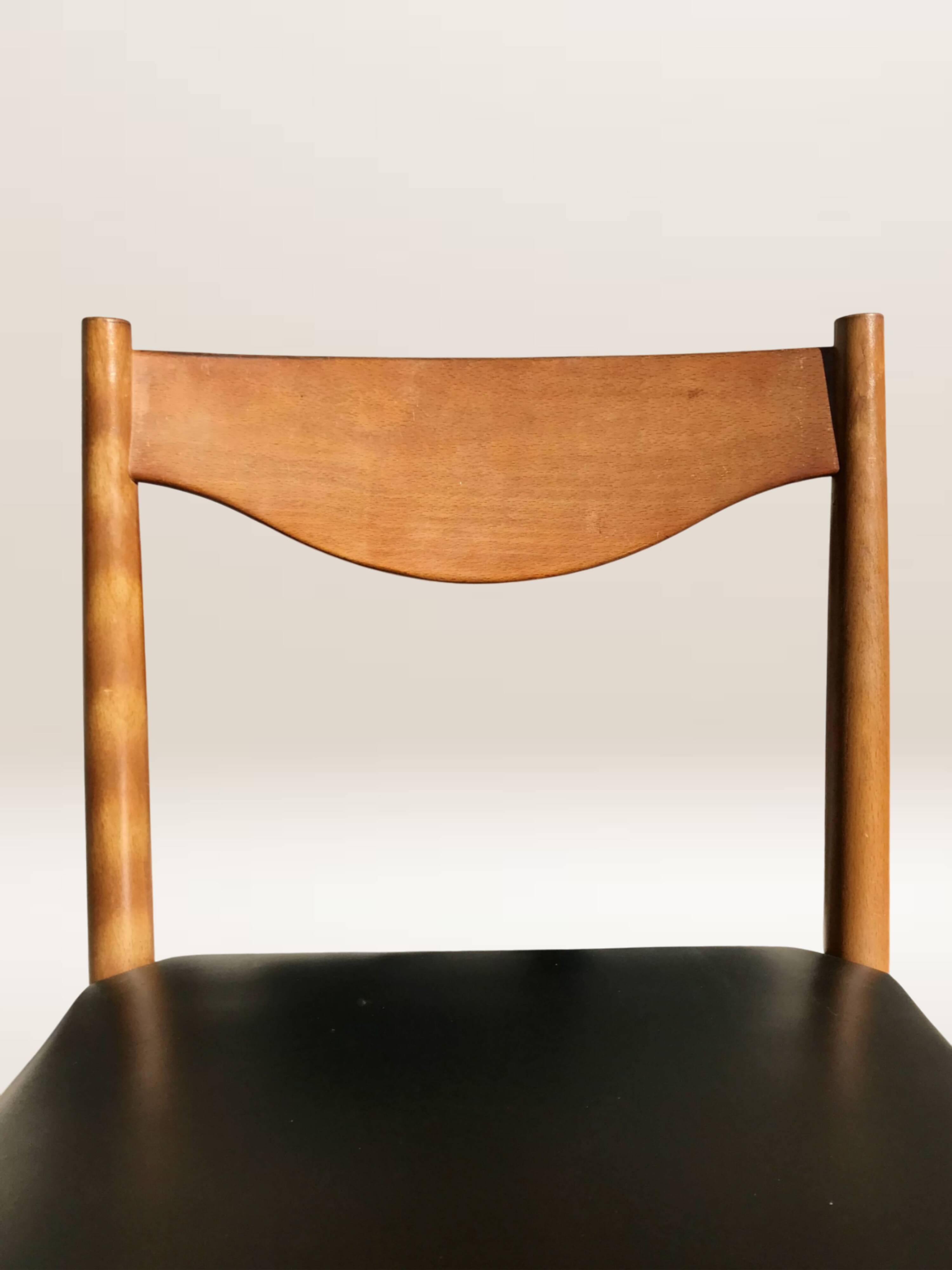 Set of 6 modernist chairs with black faux leather seats.