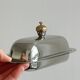 stainless steel butter dish with a golden knob