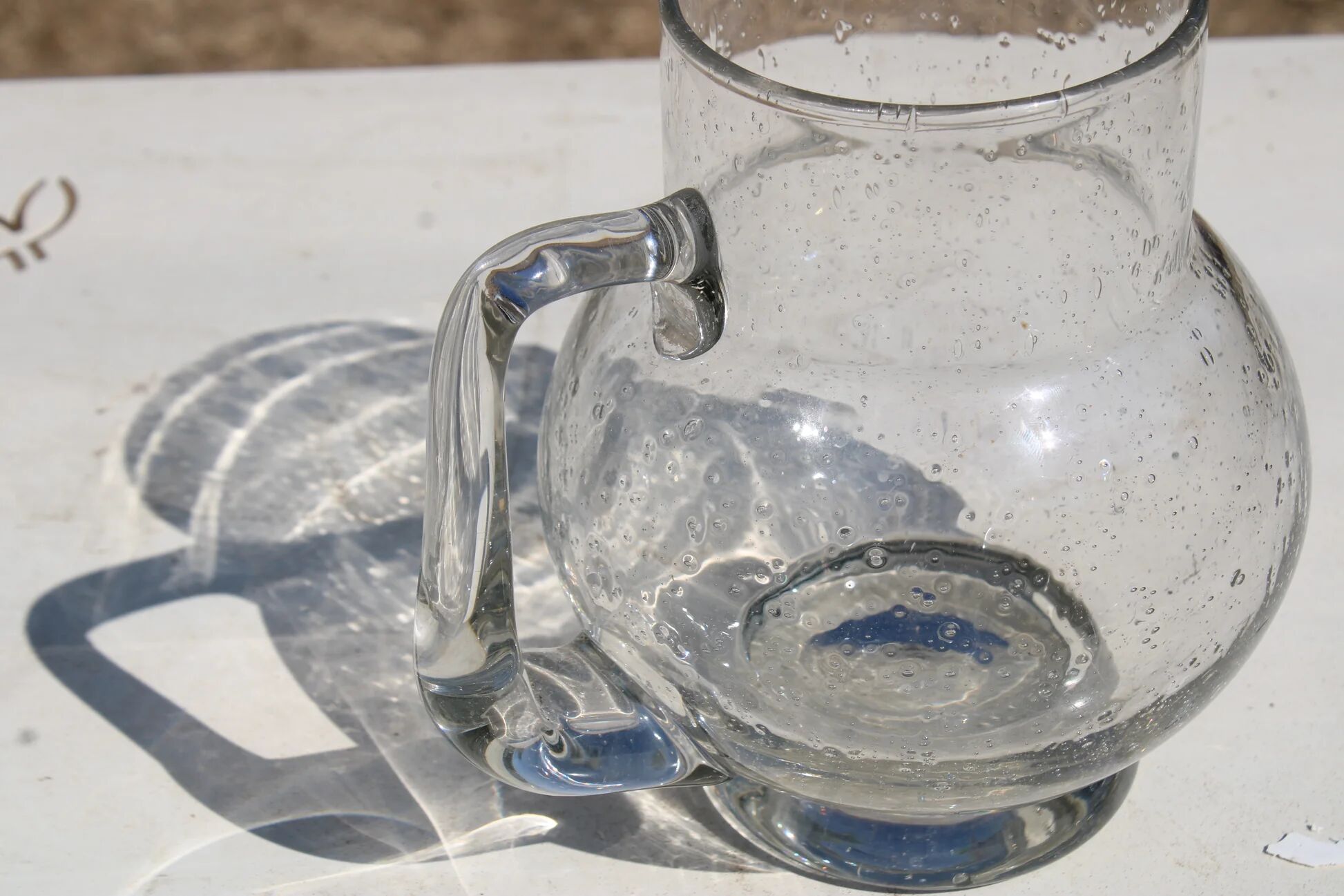 Vintage blown glass pitcher with bubbles, transparent.