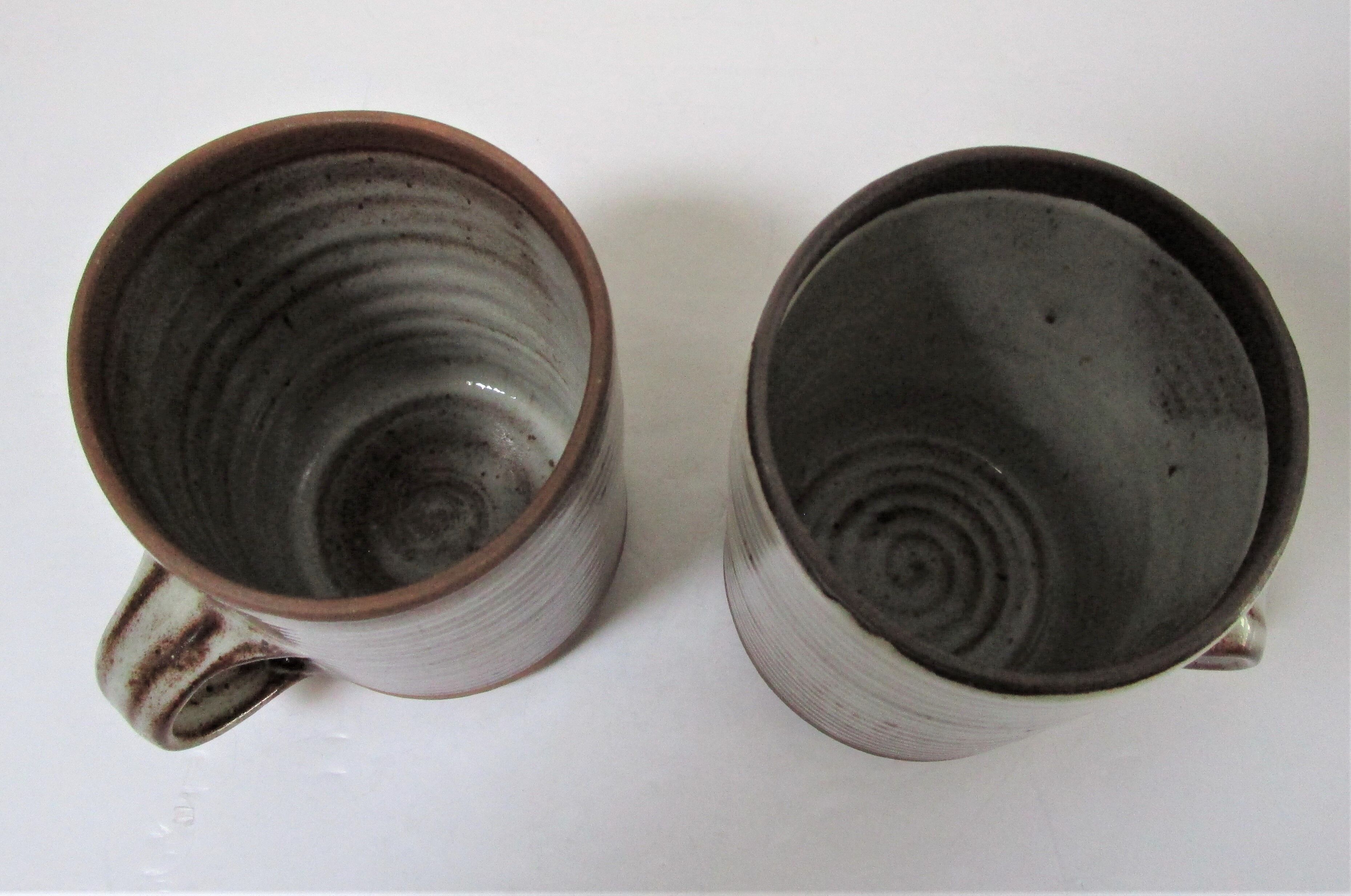 Two enamelled sandstone mugs Roger Jacques handwritten signature