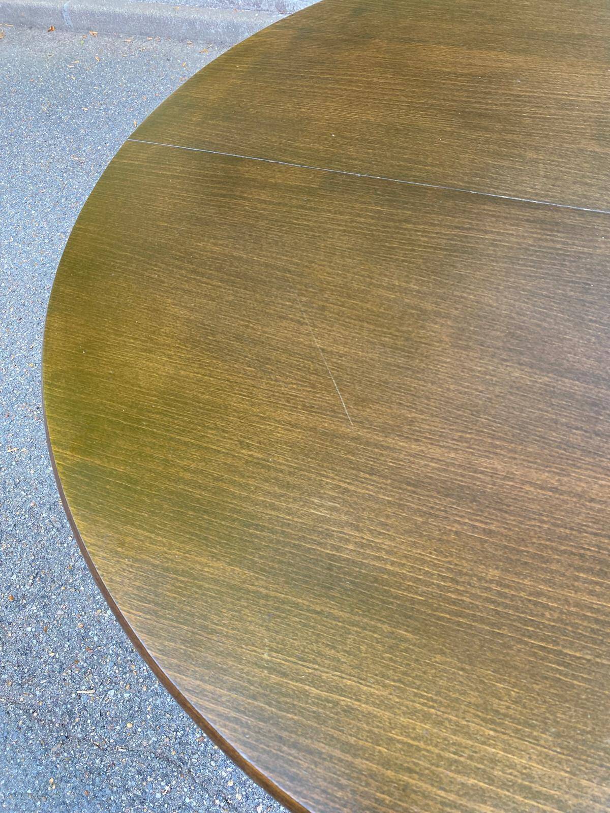 Extendable round table in solid wood with a dark oak satin finish.