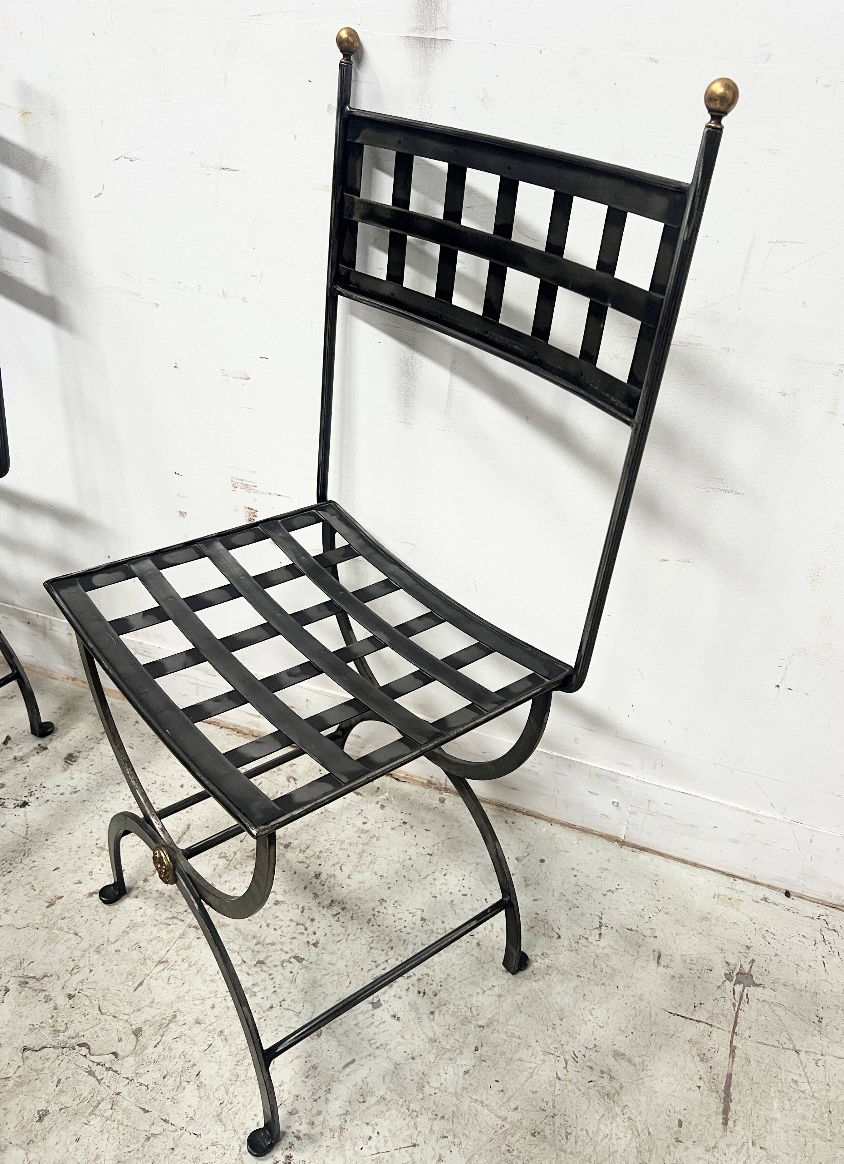 Set of four wrought iron chairs, with a reclining X-shaped base, seat and backrest.