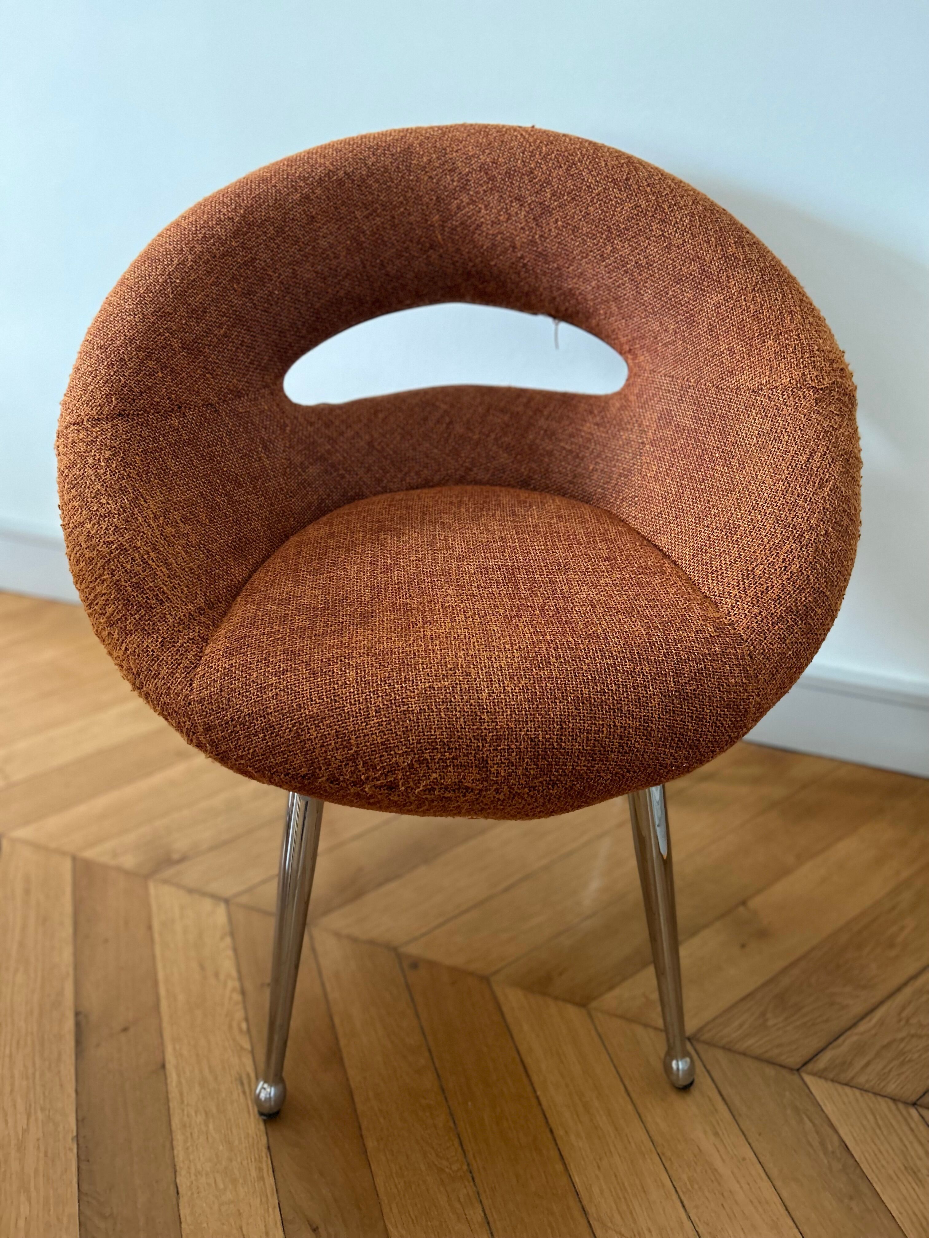 Circular armchair trimmed with orange fabric