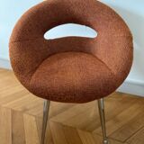 Circular armchair trimmed with orange fabric